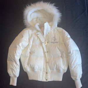 A white baby phat puffer jacket with hood and gold accent.
